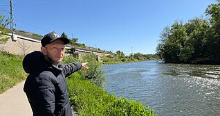 Adam Gonsior, der Retter von Lauffen, zeigt auf die entfernte Stelle im Neckar, wo er die Mutter und ihr Kind im Wasser gesehen hat.