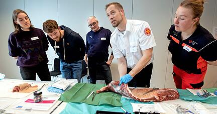 Benjamin Lorenz vom ASB zeigt den Teilnehmern, wie er einen Schlauch in einen Schweinebrustkorb eingeführt. 
Foto: Andreas Veigel