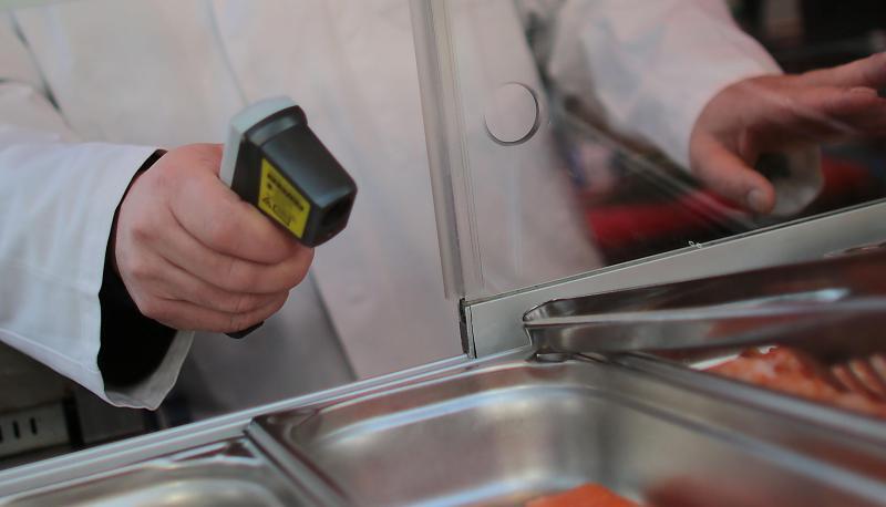 Ein Kontrolleur misst die Temperatur von Lebensmitteln. Themenfoto: dpa