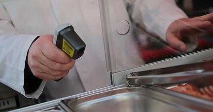 Ein Lebensmittelkontrolleur misst die Temperatur von Lachs. Foto: Oliver Berg/Archiv