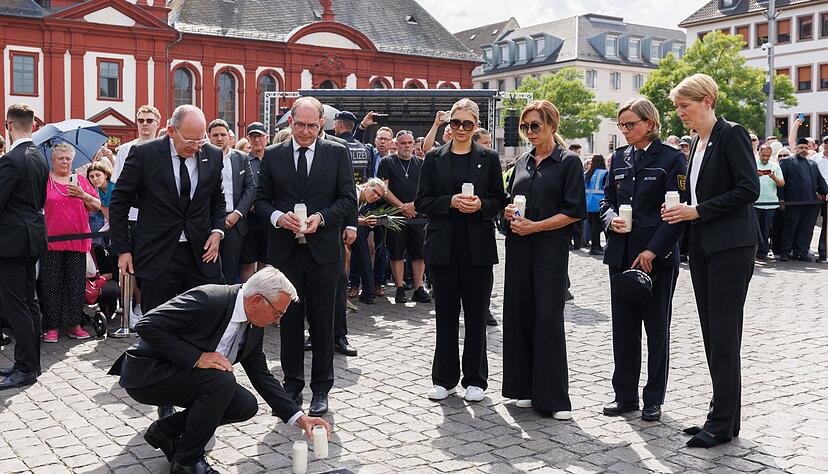 Baden-W&uuml;rttembergs Innenminister Thomas Strobl (CDU) stellt eine Kerze an einer Bodenplatte auf, die in Gedenken an Rouven Laur auf dem Marktplatz eingelassen wurde.