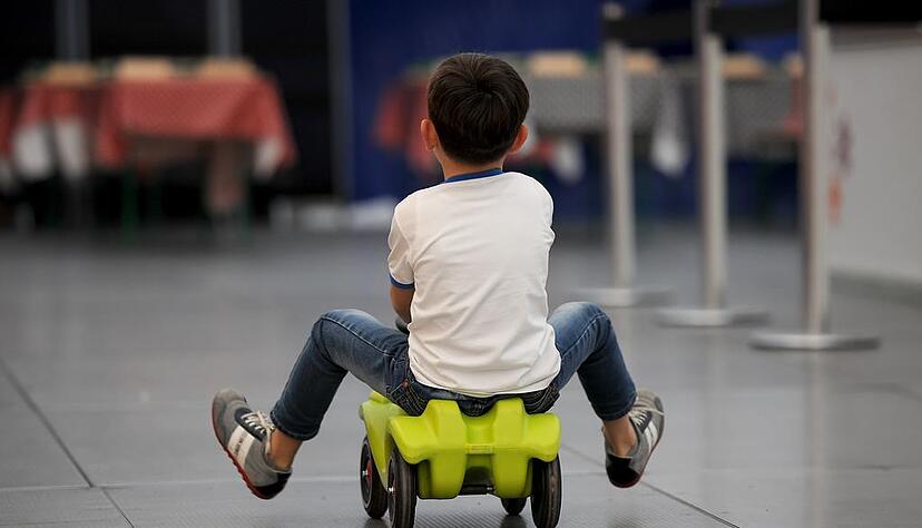 ARCHIV - Ein Junge fährt am 09.04.2015 in Berlin in einer Traglufthalle, die als Notunterkunft für Flüchtlinge dient, mit einem Spielauto. Foto: Britta Pedersen/dpa (zu dpa "Müller: Wir brauchen bei Flüchtlingen mehr Hilfe vom Bund" vom 31.07.2015) +++(c) dpa - Bildfunk+++
