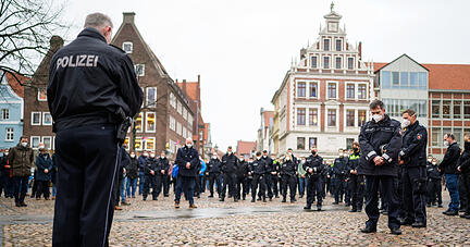 Niedersachsen, Lüneburg: Polizisten stehen während einer Schweigeminute für die in Rheinland-Pfalz getöteten Polizisten auf dem Marktplatz zusammen.