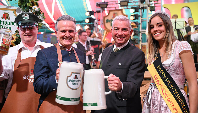Frank Nopper (2.v.l , CDU), Oberbürgermeister von Stuttgart, hält Cannstatter Wasen zur Eröffnung zusammen mit Thomas Strobl (2. v.r, CDU), Innenminister von Baden-Württemberg, das erste Bier in der Hand. Rechts die Baden-Württemberhische Bierkönigin Amy.