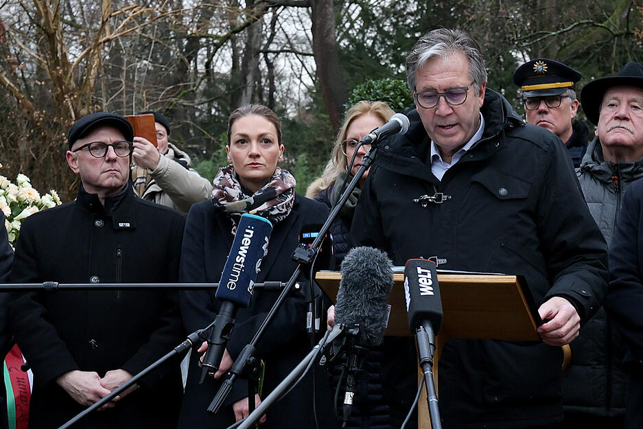 Jürgen Herzing (SPD, vorn, r), Oberbürgermeister von Aschaffenburg, spricht bei der Kranzniederlegung nach dem tödlichen Angriff in einem Park neben Judith Gerlach (CSU), bayerische Staatsministerin für Gesundheit, Pflege und Prävention, und Eric Leiderer (SPD, l), Bürgermeister von Aschaffenburg.
