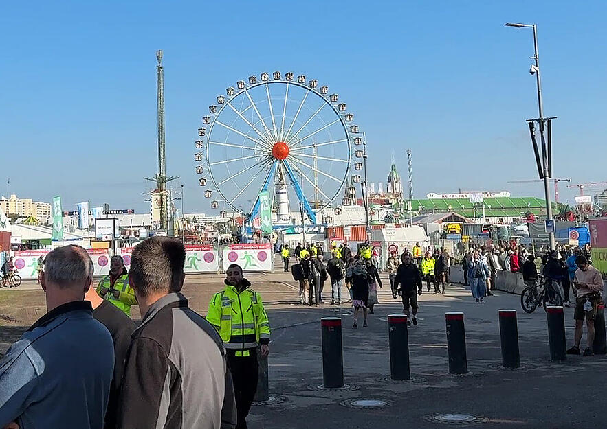 Polizei und Sicherheitsdienst sind am gesperrten Wiesn-Festgelände unterwegs. Im Laufe des Tages soll entschieden werden, ob das Oktoberfest trotz Bombendrohung noch öffnen kann.