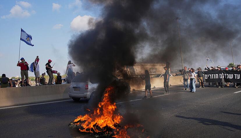 Israelische Demonstranten blockieren eine Stra&szlig;e bei einem Protest.