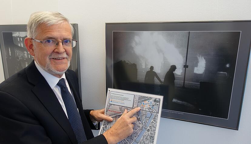 Stadtarchivdirektor Christhard Schrenk zeigt auf dem Stadtplan, wo das Bild des Fotografen Max Richard Platte dahinter entstanden ist.
Foto: Christian Gleichauf