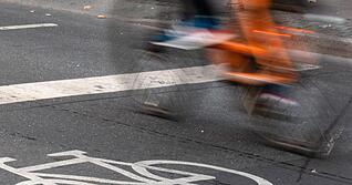 Ein Fahrradfahrer fährt in der Innenstadt über einen Radweg.