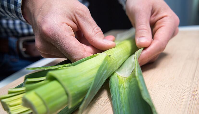 Profi-Tipp: Nachdem die &auml;u&szlig;eren Bl&auml;tter entfernt wurden, schneidet man die Lauchstangen l&auml;ngs ein und reinigt sie unter flie&szlig;endem Wasser.