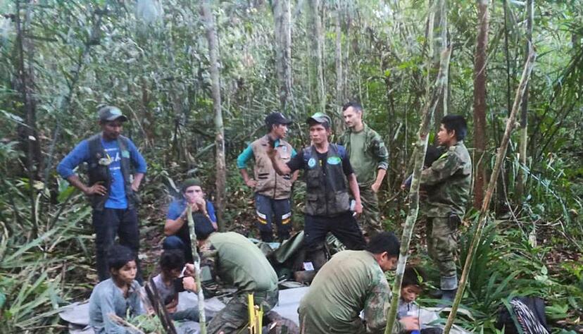 Soldaten und indigene M&auml;nner k&uuml;mmern sich um die vier Geschwister.