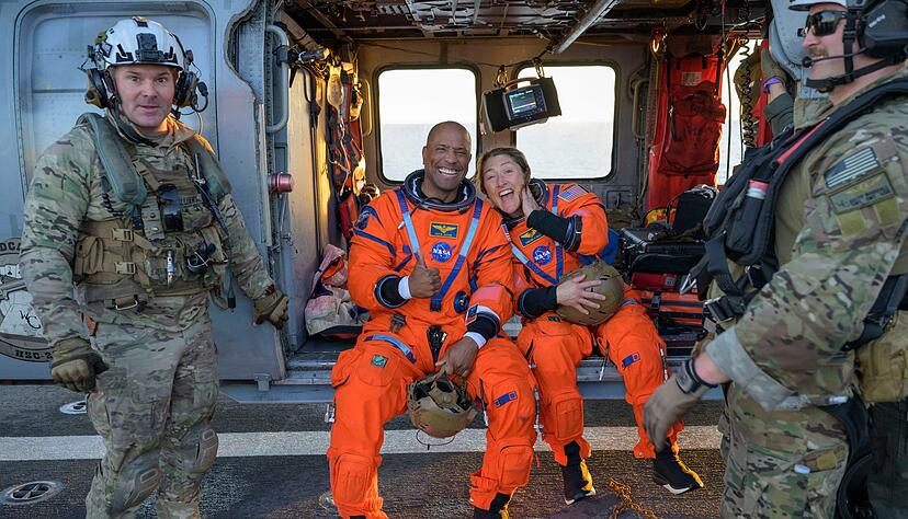 Die Astronauten Victor Glover und Christina Koch sitzen auf einem Hubschrauber der Navy auf dem Flugdeck des Schiffs USS John P. Murtha, nachdem sie aus ihrem &laquo;Orion&raquo;-Raumschiff geholt wurden.