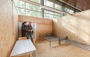 Daniela Wenninger und Benjamin Fink in einem der Zimmer in der M&uuml;hlrainhalle. Seit Juli bringt die Stadt Weinsberg hier ukrainische Kriegsfl&uuml;chtlinge unter.