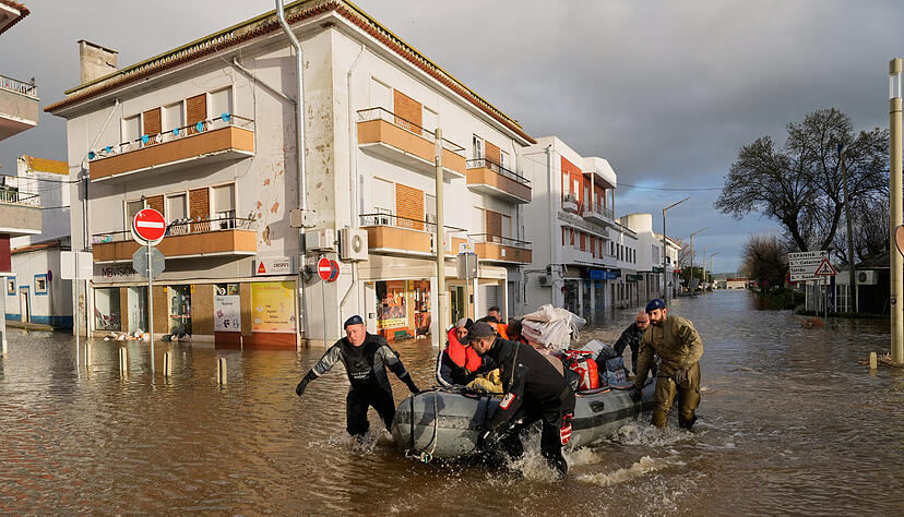 Polizisten und Marinesoldaten evakuieren Bewohner eines Hotels mit Schlauchbooten aus einer &uuml;berschwemmten Stra&szlig;e, nachdem der Fluss Sado nach heftigen Regenf&auml;llen in Alcacer do Sal in S&uuml;dportugal &uuml;ber die Ufer getreten ist.