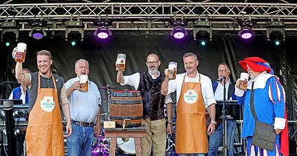 Premiere für Bürgermeister Andreas Zaffran (links) bei der Eröffnung des Talmarkts: Drei Schläge mit dem Hammer benötigt er, dann läuft das Bier.
Foto: Ralf Seidel