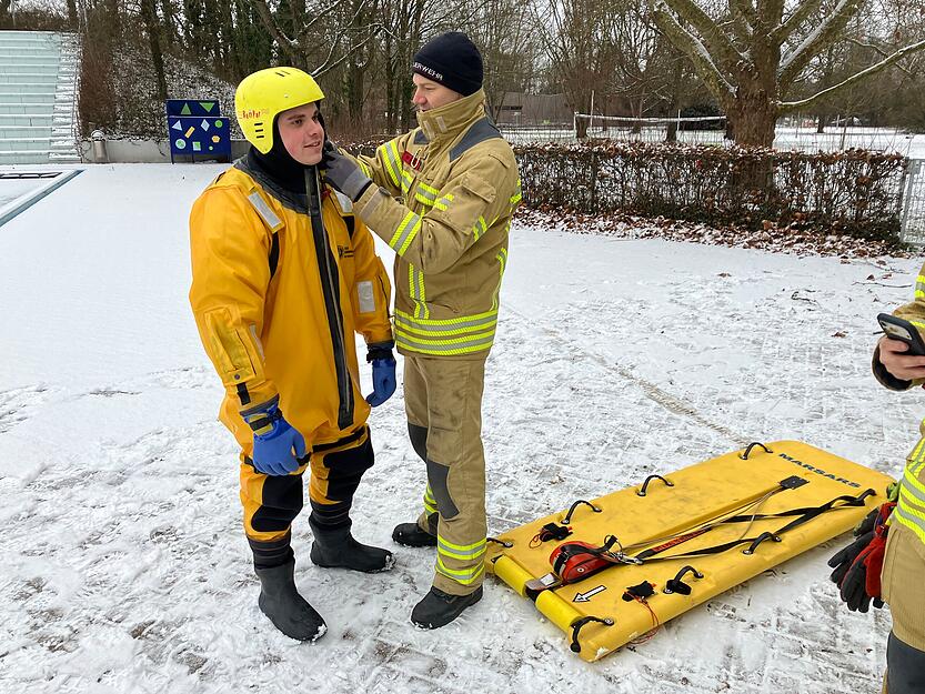 An Land werden die Vorbereitungen f&uuml;r die Eisrettung getroffen. Die Feuerwehr Heilbronn probt im Freibad Neckarhalde den Ernstfall.