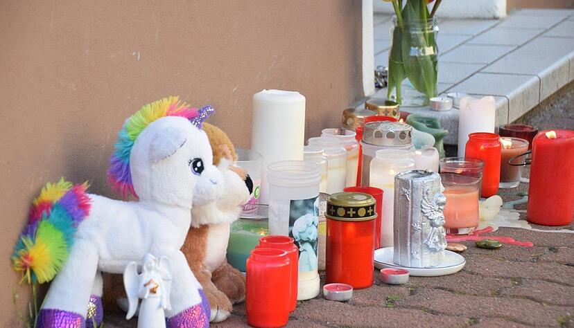 Pl&uuml;schtiere und Kerzen stehen am Hauseingang zum Tatort in einer Wohnung in Hockenheim.
