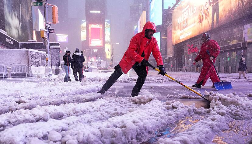 Ein Arbeiter schaufelt Schnee auf dem Times Square in New York. Ein heftiger Schneesturm zieht &uuml;ber den Nordosten der USA hinweg.