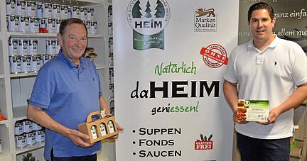 Firmengründer Josef Heim (links) und sein Sohn Kevin, der den Betrieb seit 2004 leitet, vor einem Regal mit Feinkostkonserven.
Foto: Josef Staudinger