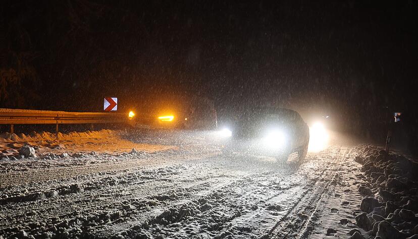 Autofahrer sind auf einer verschneiten Straße bei Niedernhausen (Hessen) unterwegs.