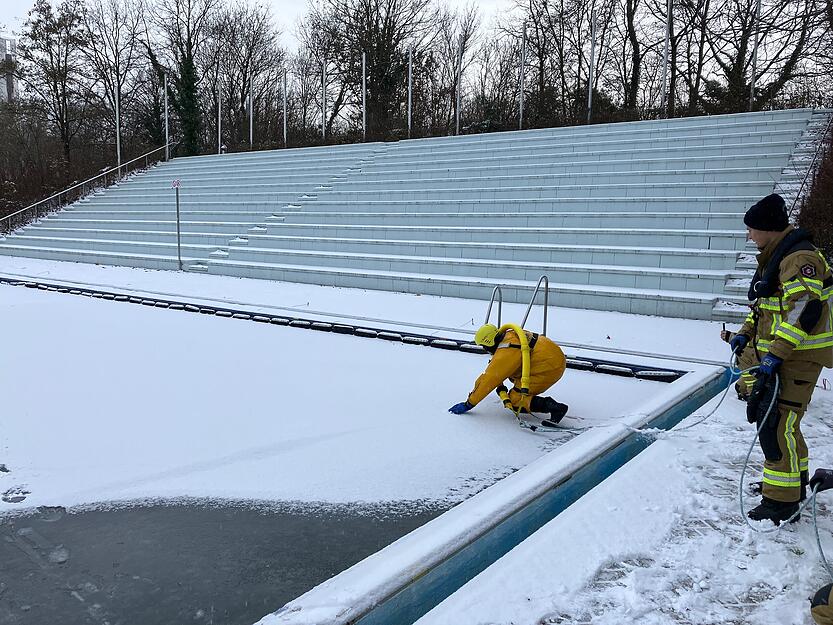Vorsichtig begibt sich der Retter der Feuerwehr Heilbronn aufs Eis im Freibad Neckarhalde. Geprobt wird eine Eisrettung.