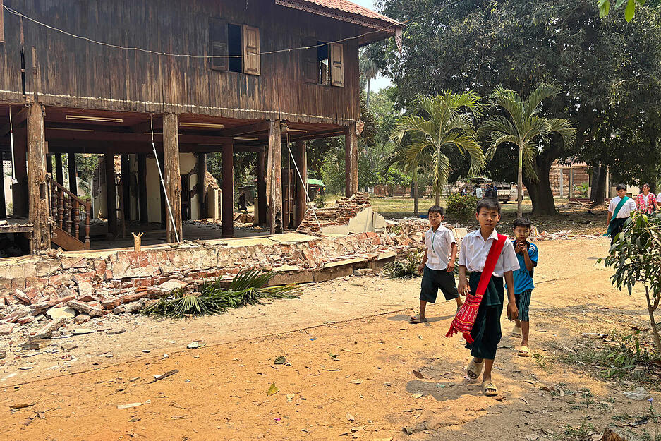 Kinder gehen in Naypyitaw, Myanmar, nach dem Erdbeben in der Nähe eines beschädigten Klosters.