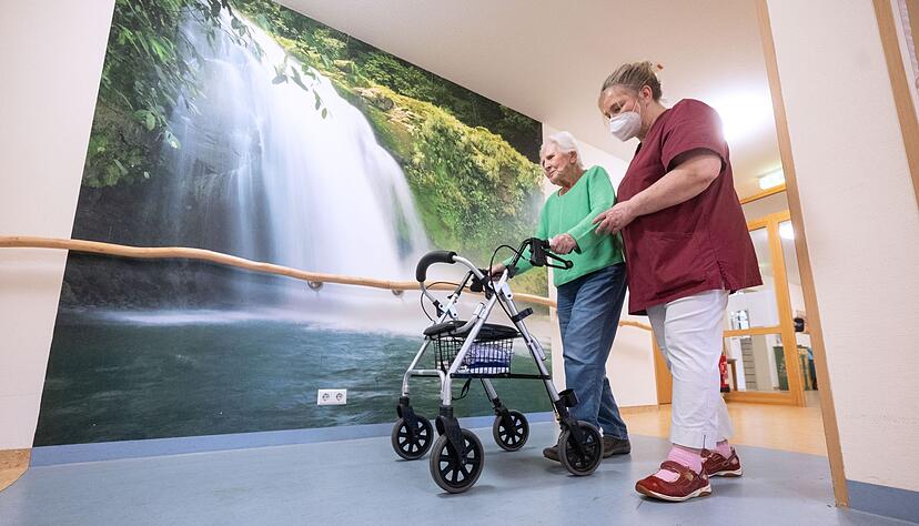 Eine Mitarbeiterin geht mit einer Bewohnerin in einem Pflegeheim in Niederstetten. Eine Mitarbeiterin geht mit einer Bewohnerin in einem Pflegeheim in Niederstetten.