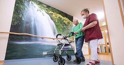 Eine Mitarbeiterin geht mit einer Bewohnerin in einem Pflegeheim in Niederstetten. Eine Mitarbeiterin geht mit einer Bewohnerin in einem Pflegeheim in Niederstetten.