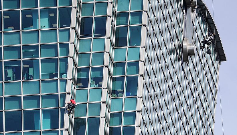 Schaulustige beobachteten Alex Honnold nicht nur vom Boden aus - auch hinter den B&uuml;rofenstern wurde der Extremsportler angefeuert.