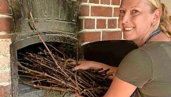 Marion Jung heizt mit Reben zwischen den Backvorgängen noch einmal richtig ein. Marion Jung heizt mit Reben zwischen den Backvorgängen noch einmal richtig ein.