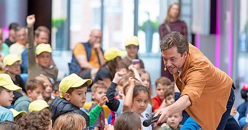 Mittendrin statt nur auf der B&uuml;hne: Tobias Krell interessiert sich f&uuml;r die Kinder. Die sind gebannt von seinem Erz&auml;hlen. Ein Nachmittag zum Lachen und Staunen, der im Vorfeld ruckzuck ausgebucht war. Fotos: Mario Berger