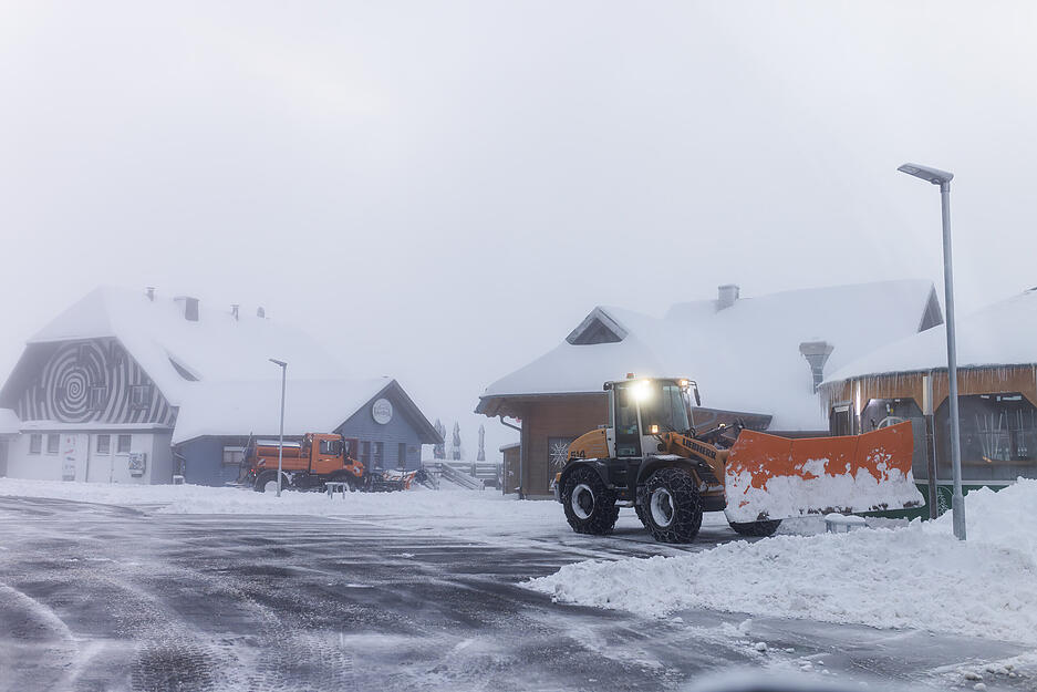 Räumfahrzeuge befreien einen Parkplatz an der Feldberger Passhöhe vom Schnee, der am Vortag und während der Nacht gefallen ist.