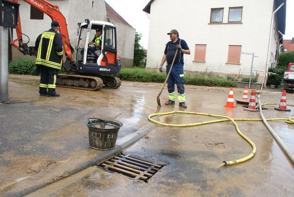 Mit Bagger und Schlauch wird die Kreuzung Großen Hasengasse/Mühlstraße (Ilsfeld) gereinigt.