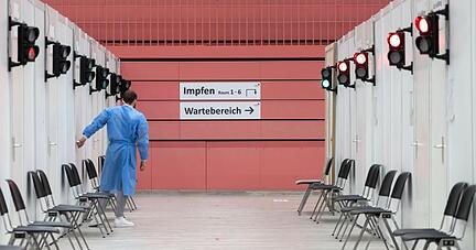 Ein Mitarbeiter des Impfzentrums Tübingen steht in der Paul-Horn-Arena in einem Gang.