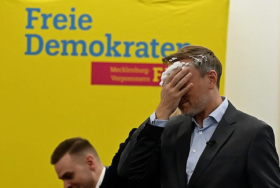 Lindner wischte sich nach dem Angriff den Schaum aus dem Gesicht. &bdquo;Sahne w&auml;re mir lieber gewesen. Ich trage diese Kampfspuren mit Stolz&ldquo;, soll er nach dem Vorfall gesagt haben. (Screenshot aus einem Video).