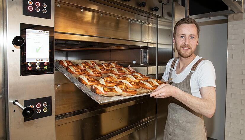 Michael Haase holt frische Brezeln aus dem Backofen. Die Brotmanufaktur 280 Grad in der Charlottenstra&szlig;e setzt auf urspr&uuml;ngliche Backwaren.
Foto: Andreas Veigel