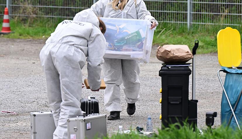Mitarbeiter der Spurensicherung der Polizei untersuchen einen Tatort an dem mehrere Schüsse gefallen sind.