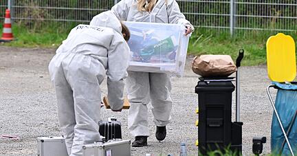Mitarbeiter der Spurensicherung der Polizei untersuchen einen Tatort an dem mehrere Schüsse gefallen sind.