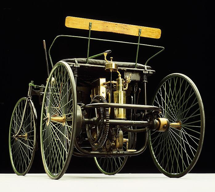 Maybach konstruiert den eleganten, leichten und technisch fortschrittlichen Stahlradwagen 1889 als komplettes Automobil. Er ist ausgestattet mit Zweizylinder-V-Motor, wassergekühlten Zylinderköpfen, Rohr-Umlaufkühlung, Glührohrzündung, Schwimmervergaser und dem ersten Viergang-Zahnradgetriebe der Welt