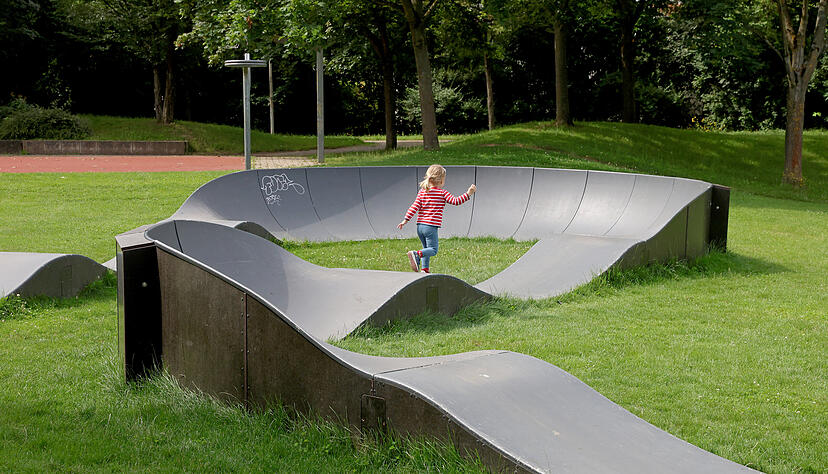 Das Mädchen hat Spaß daran, auch zu Fuß über die Wellen und durch die Kurven zu laufen. Die Pumptrackanlage ist eigentlich für Rollen und Räder vom Skateboard über Rollschuhe bis hin zum BMX-Rad geeinget. Das Mädchen hat Spaß daran, auch zu Fuß über die Wellen und durch die Kurven zu laufen. Die Pumptrackanlage ist eigentlich für Rollen und Räder vom Skateboard über Rollschuhe bis hin zum BMX-Rad geeinget.