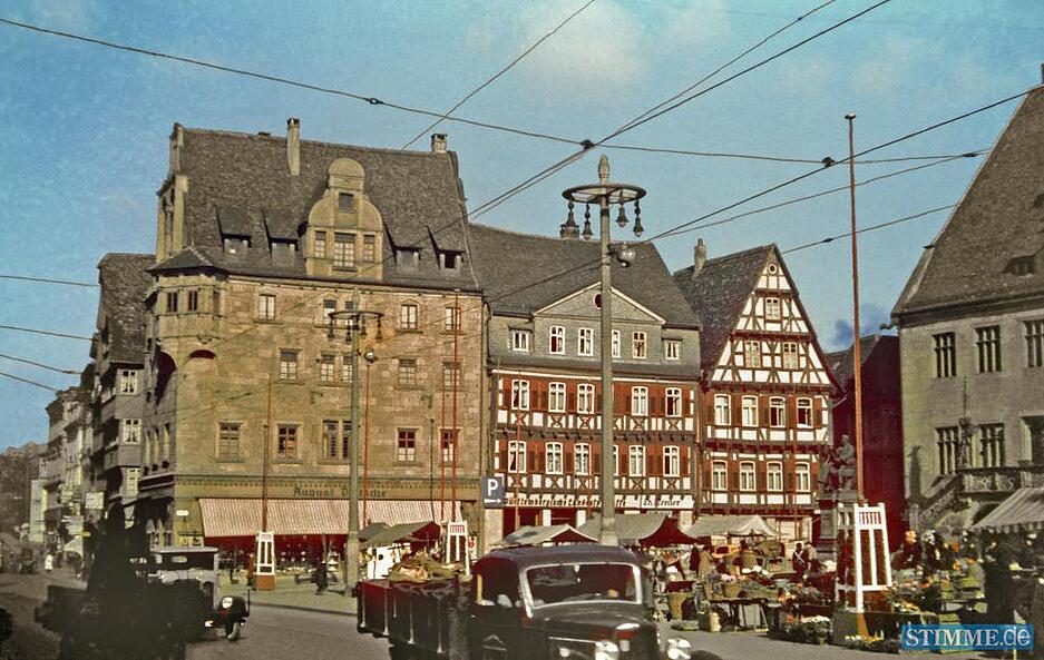Aufnahme des Marktplatzes nach 1934. Der Wochenmarkt am Fuße des Robert Mayer Denkmals, rechts im Bild, belebt den Platz.