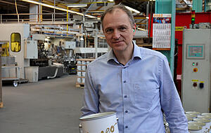 Envases: CEO Martin L&uuml;er mit einer frisch produzierten Farbdose im &Ouml;hringer Werk 1.