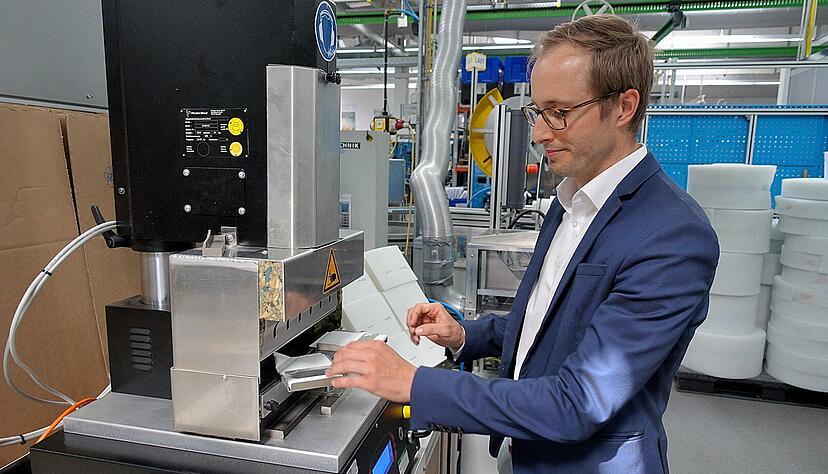 Thomas Gaugler legt das geknickte Vlies in das Ultraschallschwei&szlig;ger&auml;t. Dort verbindet sich das Material durch Reibungsw&auml;rme. In wenigen Arbeitsschritten ist eine Gesichtsmaske fertig.
Fotos: Christian Gleichauf