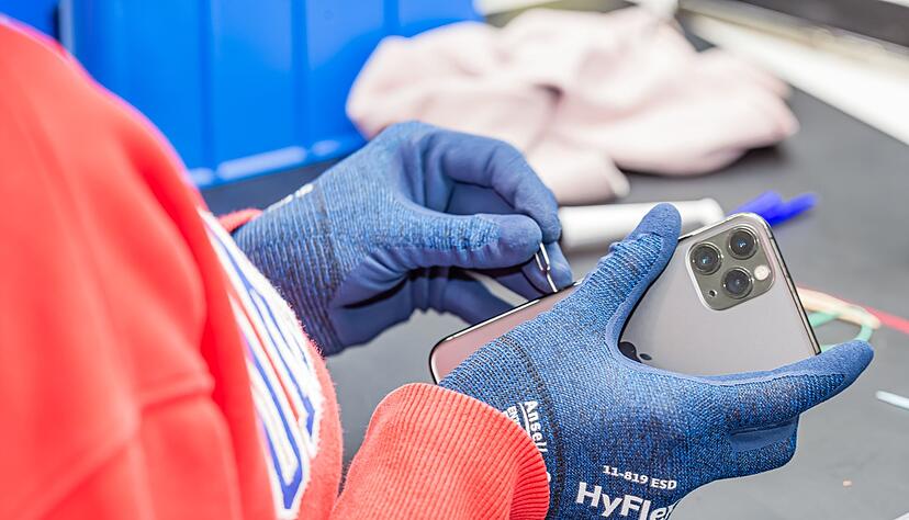 Ein Rebuy-Besch&auml;ftigter macht ein gebrauchtes iPhone flott, damit es verkauft werden kann.