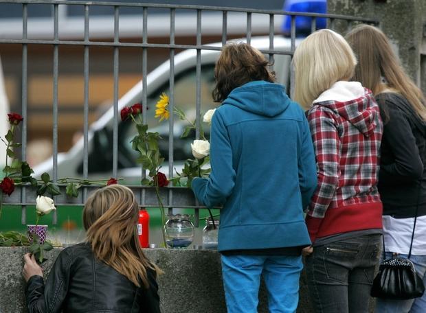 Schüler legen am Freitag auf dem Gelände des Carolinum-Gymnasiums Kerzen und Blumen zum Gedenken an den Amoklauf vom Vortag nieder.