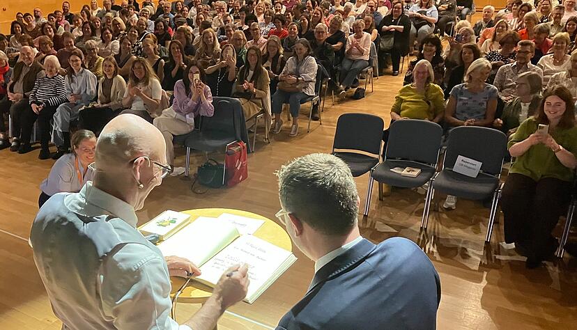 Ewald Arenz tr&auml;gt sich zu Beginn der Veranstaltung in das Goldene Buch der Stadt &Ouml;hringen ein, das ihm Oberb&uuml;rgermeister Patrick Wegener &ouml;ffnet.