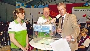 Bei der Ziehung der Gewinner: Stimme-Chefredakteur Uwe Ralf Heer, SWR-4-Moderator Fritz Wehrbach und Glücksfee Lisa Hirn.Foto: Steffan Maurhoff