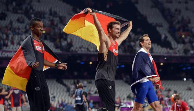 Raphael Holzdeppe (l) und Bj&ouml;rn Otto (M) begleiten Olympiasieger Renaud Lavillenie auf der Ehrenrunde. Foto: Christphe Karaba