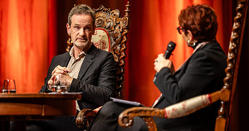 &bdquo;Ein bisschen Hybris muss man ja haben, wenn man die Schnapsidee hat, diesen Beruf zu ergreifen&ldquo;: Schauspieler J&ouml;rg Hartmann plauderte am Montagabend mit Moderatorin Bernadette Schoog.