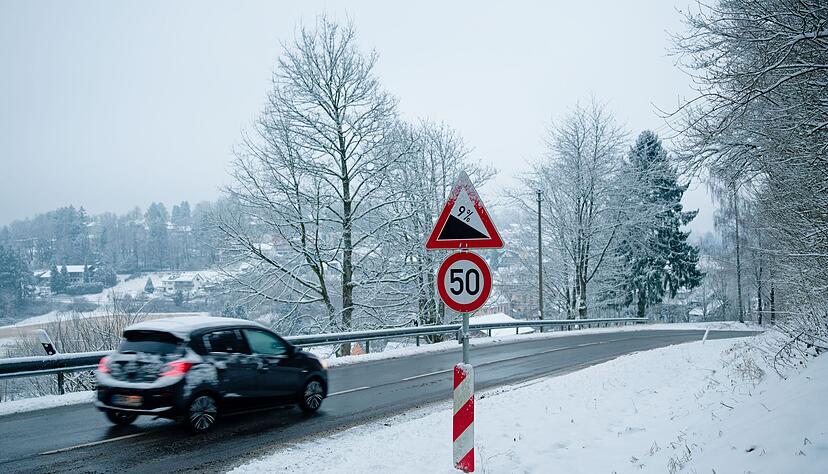 So sieht Winterwetter aus: Ein Auto f&auml;hrt in einer schneebedeckten Landschaft &uuml;ber eine Stra&szlig;e bei Wilhelmsfeld.